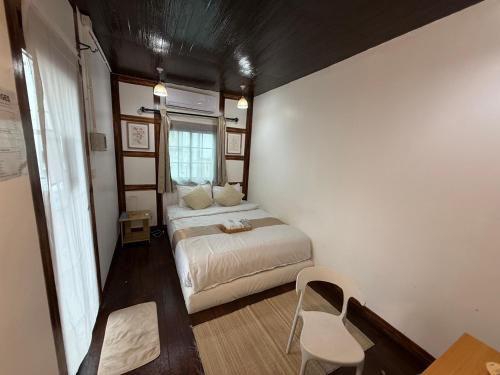 a small bedroom with a bed and a window at Bird Nest Hostel in Ko Tao