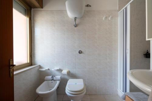 a bathroom with a toilet and a sink and a tub at B&B Cardedu in Cardedu