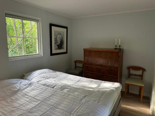 a bedroom with a bed and a dresser and a window at Orangeriet Björkelund in Skövde