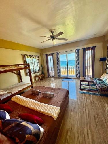 a bedroom with two beds and a ceiling fan at Surf Front Villa Samar in Maydolong