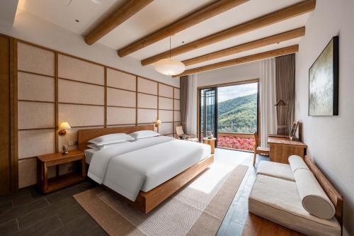 a bedroom with a large bed and a large window at ALOR VALLEY HUZHOU in Huzhou