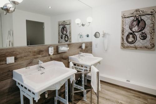 a bathroom with two sinks and a mirror at Hotel Crystal in Saarbrücken