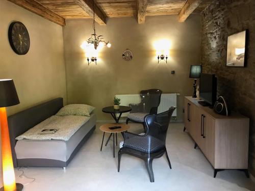 a small room with a bed and a table and chairs at Apartmány Za Zvončekom in Vydrná