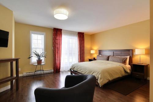 um quarto com uma cama, 2 janelas e um sofá em Gî'Temps couette et café B&B em Granby