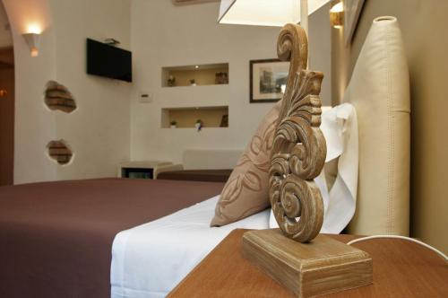 Cette chambre d'hôtel dispose d'un lit avec une planche de pied en bois. dans l'établissement Tre R Colosseo, à Rome