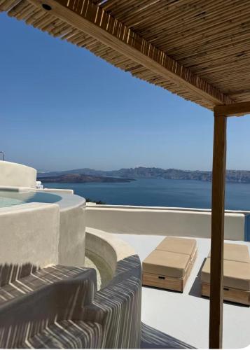 a patio with chairs and a view of the water at Akrorama private villas and suites in Akrotiri