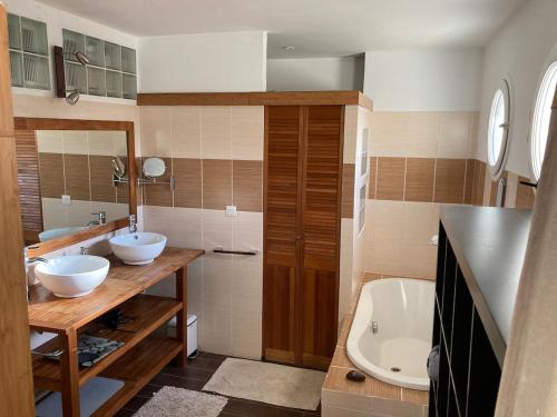a bathroom with two sinks and a bath tub at Villa ALoha in Carcans