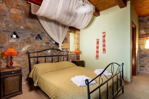 a bedroom with a bed and a stone wall at Villa Kimothoe with Private Pool, only 20 min to Elafonissi Beach in AmigdhalokeFálion