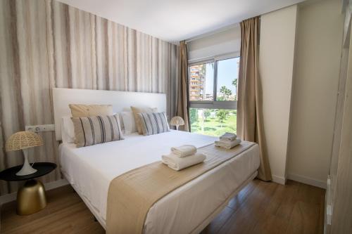 a bedroom with a large white bed with towels on it at Letplanet Playa Park in Torremolinos