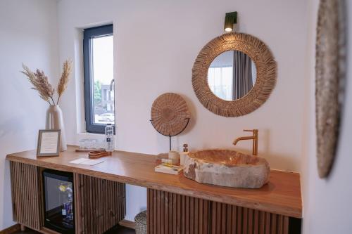 a bathroom with a large wooden sink and a mirror at By The Lake - A Frame in Căciulaţi
