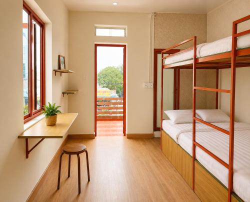a room with two bunk beds and a desk and a window at YARA - Stay & Coffee in Mỹ Ðuc