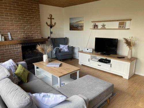 a living room with a couch and a tv at Ferienhaus Paschelke in Friedrichskoog-Spitze