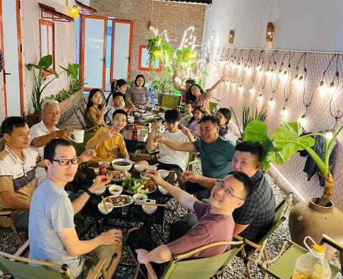 a group of people sitting at a table eating food at YARA - Stay & Coffee in Mỹ Ðuc