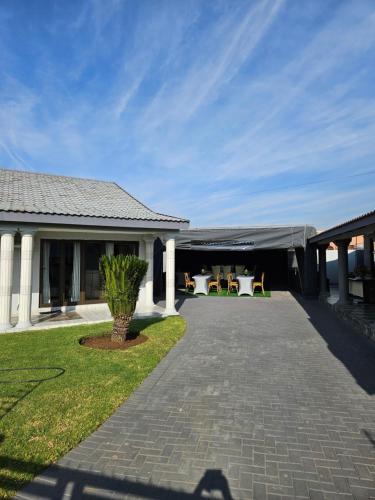 a building with a patio with tables and chairs at Elitha Boutique Bed and Breakfast in Mogwase