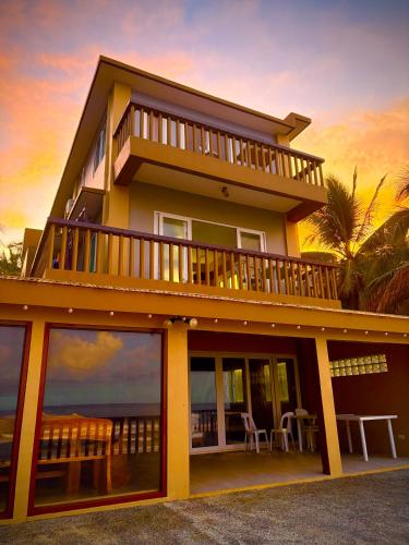 a house with a balcony with a view of the ocean at Surf Front Villa Samar in Maydolong