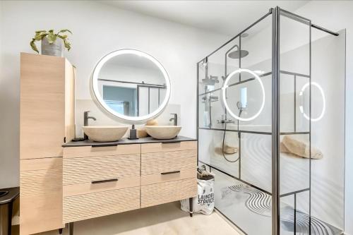 a bathroom with two sinks and a mirror at Villa Émeraude Spa in Le Porge
