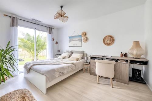 a bedroom with a bed and a desk at Villa Émeraude Spa in Le Porge