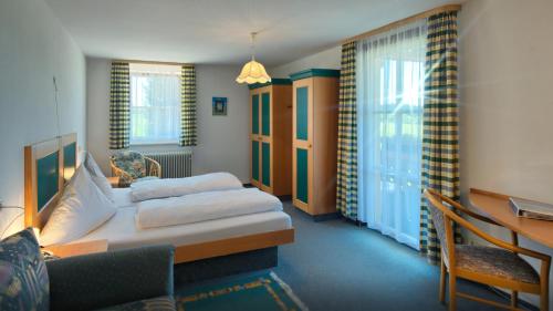 a hotel room with a bed and a desk and window at Landgasthof Zum Schwanen in Hornberg