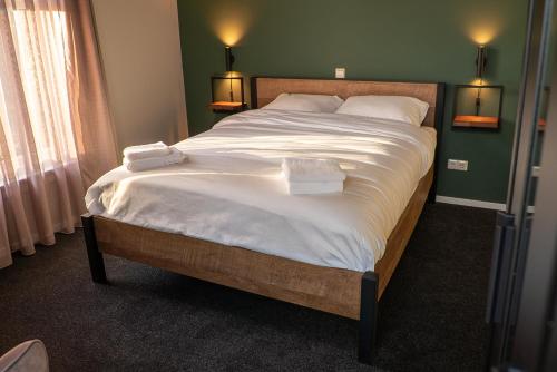 a bedroom with a large bed with two towels on it at Restaurant & Hotel De Jaeger in Ruurlo