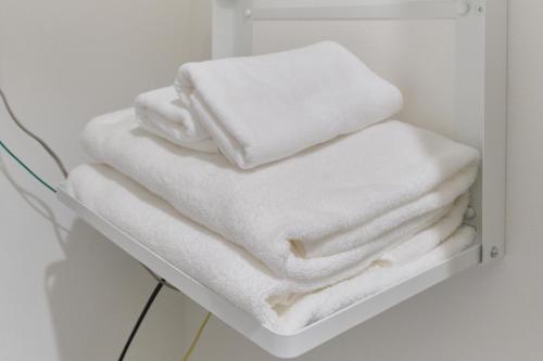 a stack of white towels sitting on a shelf at Cavatina in Sapporo