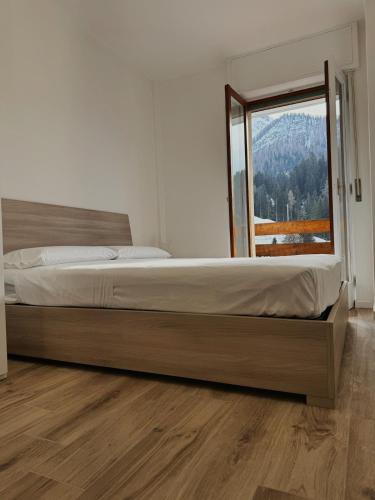 a bedroom with a large bed with a large window at Foppolo GH in Foppolo