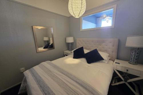 a bedroom with a white bed and a mirror at The Opera View Suite in Oamaru