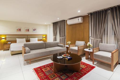 a hotel room with a bed and a couch and a table at Hotel Excelsior Karachi in Karachi