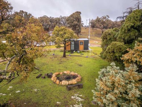 a cabin in a field with a fire pit in the grass at Sparkling Tiny House by Tiny Away in Windeyer
