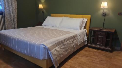 a bedroom with a bed and a nightstand with a bed sidx sidx at Guest house dei nonni in Anticoli Corrado