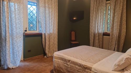 a bedroom with a bed and two windows at Guest house dei nonni in Anticoli Corrado