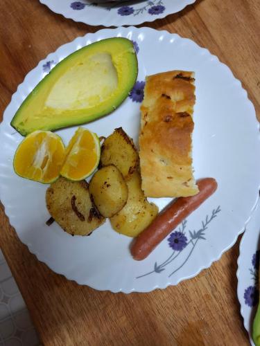 a plate of food with a piece of fish and potatoes and a pickle at G4 homez in Morogoro