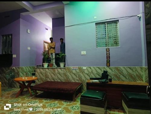 a large screen in a room with two men in a room at Pallavi girl hostel in Laheria Sarāi