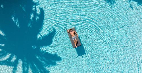 a person on a paddle board in the water at Paralos Irini Mare in Agia Galini