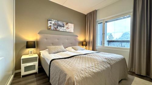 a bedroom with a bed and a window at Red Apartment 19 in Tahkovuori