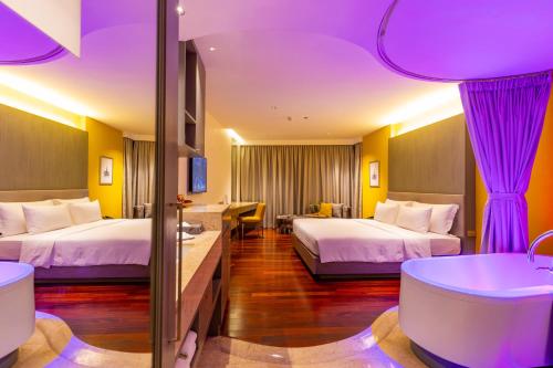 a hotel room with two beds and a tub at LiT BANGKOK Hotel in Bangkok