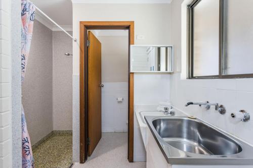 a bathroom with a sink and a mirror at Emu Beach Chalets in Albany