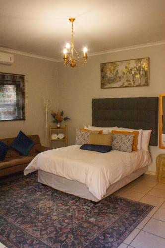 a bedroom with a large bed and a couch at Windhoek self accommodation in Windhoek