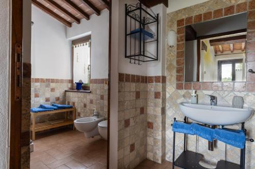a bathroom with a sink and a toilet at Casale Tiziano by PosarelliVillas in Citerna