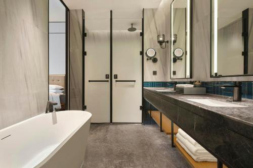a bathroom with two sinks and a bath tub at Four Points by Sheraton Shanwei Lufeng in Shanwei