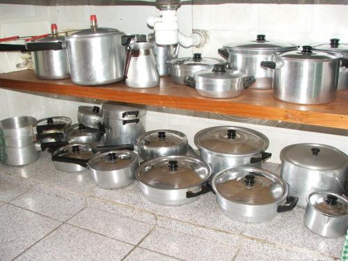 a bunch of pots and pans on a shelf in a kitchen at Pousada Flor de Aurora Bertioga in Bertioga