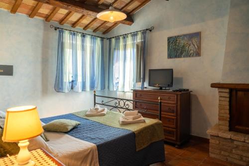 a bedroom with a bed with a lamp and a television at Casalantico in Corinaldo