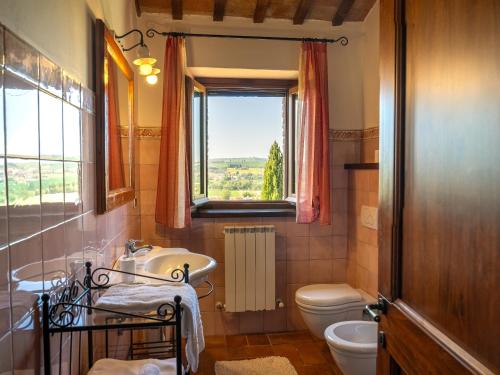 a bathroom with a sink and a toilet and a window at Casalantico in Corinaldo