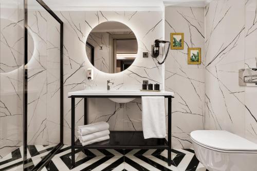 ein Badezimmer mit Waschbecken und Spiegel in der Unterkunft The New Hotel Zeybek in Izmir