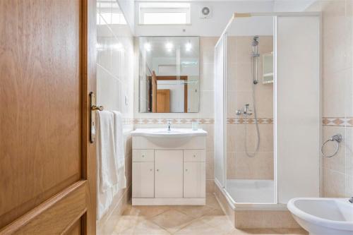 a white bathroom with a sink and a shower at Casa Campo in Loulé