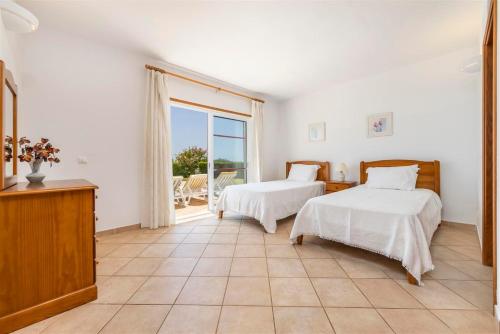 a bedroom with two beds and a large window at Casa Campo in Loulé