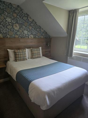 a large bed in a bedroom with a window at Rooms by the Oak in Baginton