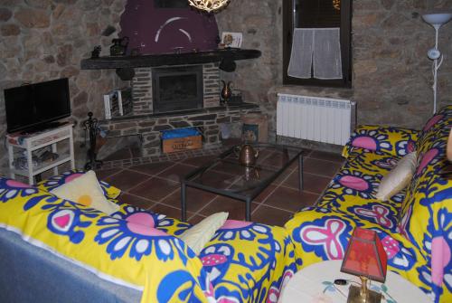 a living room with a couch and a fireplace at Casa Rural Romanejo in Cabezabellosa