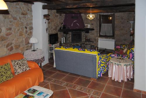 a living room with a couch and a fireplace at Casa Rural Romanejo in Cabezabellosa