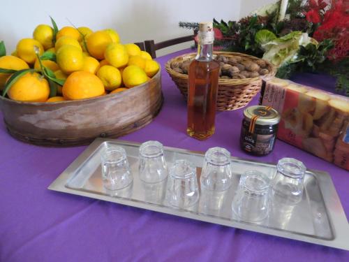 una mesa púrpura con una bandeja de vasos y un bol de fruta en Quinta Machado Da Pedra Bela, en Gerês