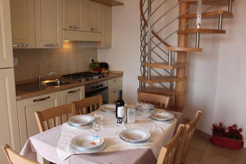 a kitchen with a table with plates and wine glasses at Aba Village RTA in Puntone di Scarlino